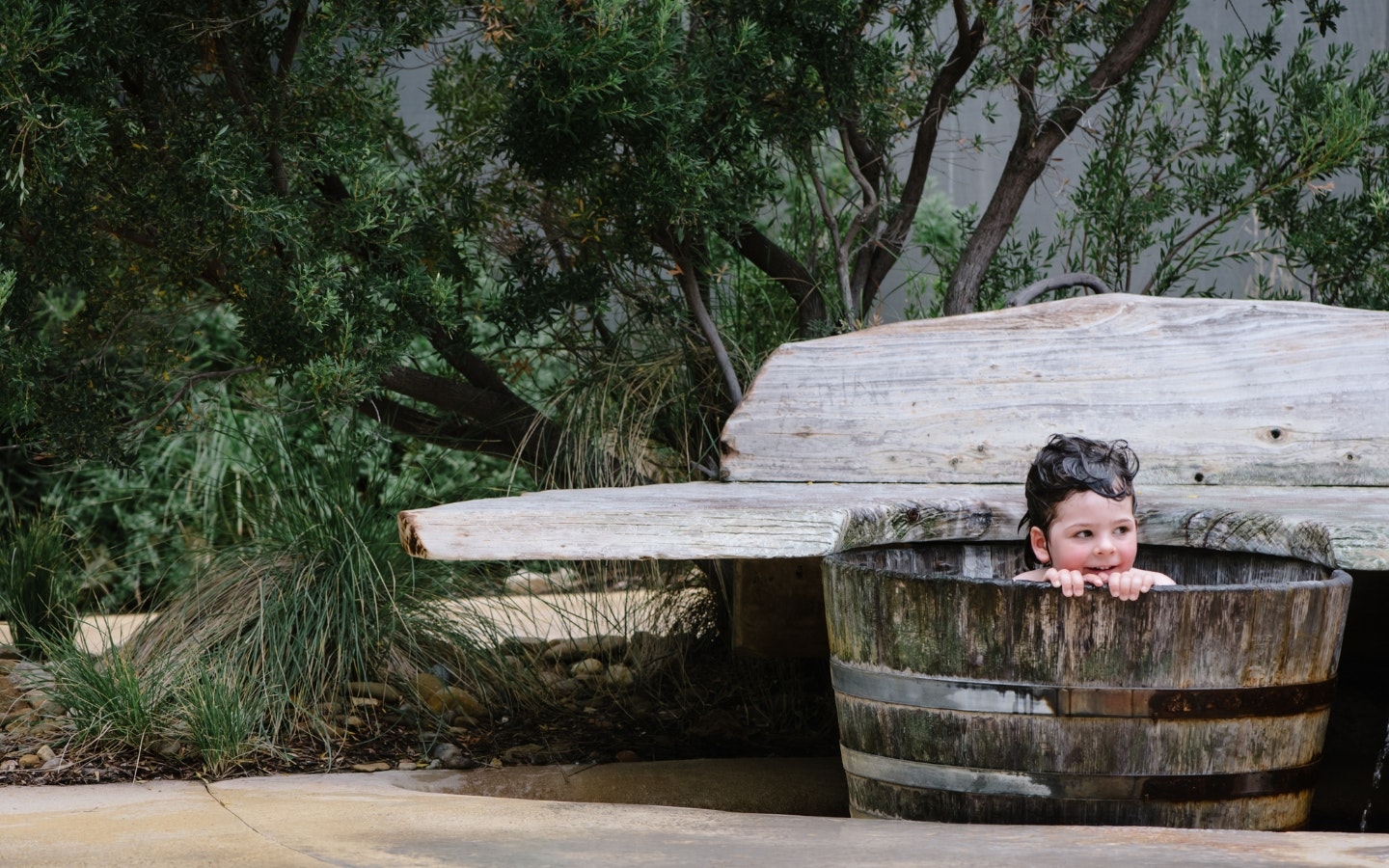 child bathing in barrel