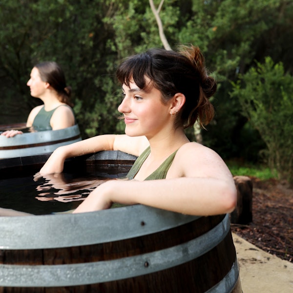 A young woman in a bathing barrel filled with geothermal water