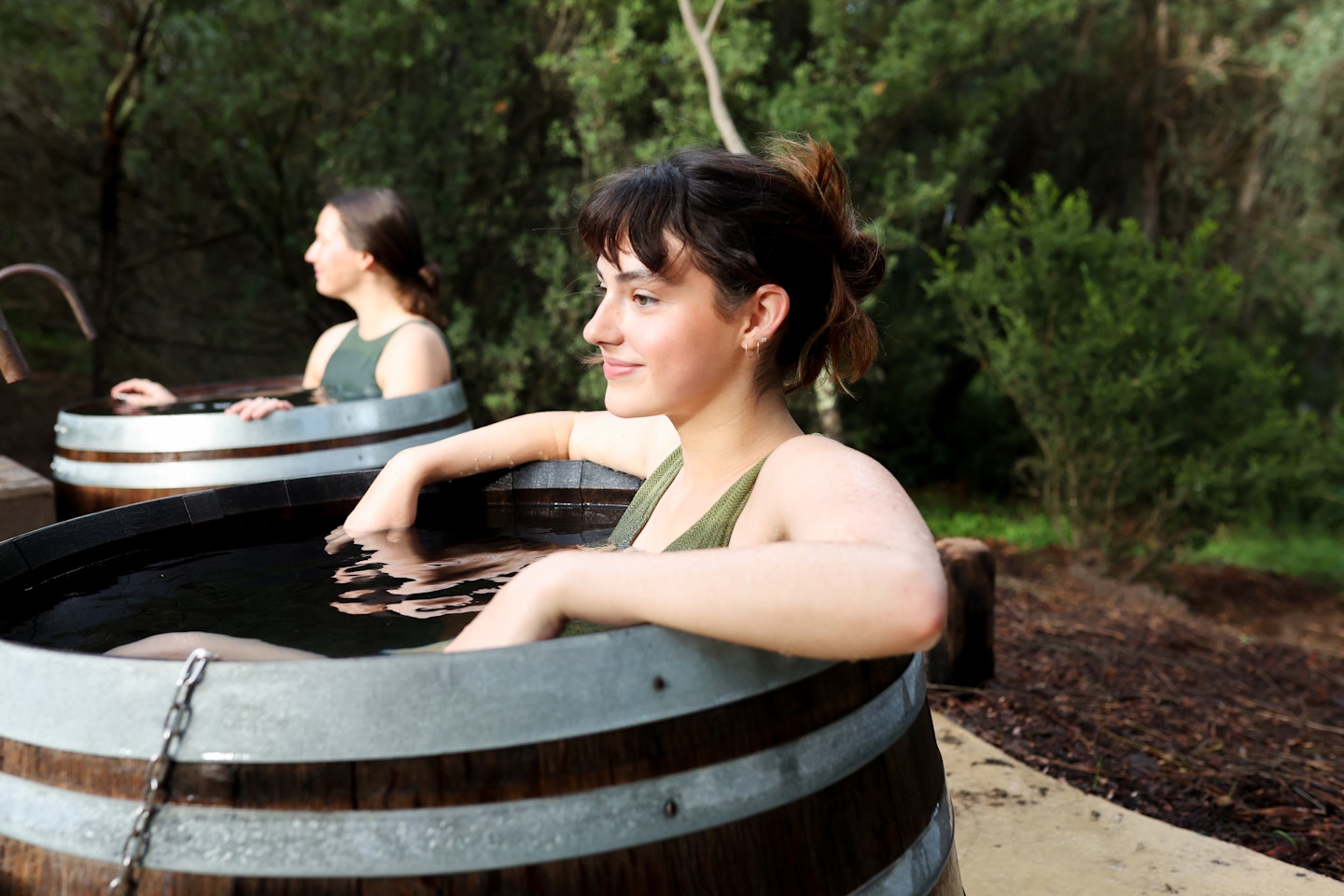 A young woman in a bathing barrel filled with geothermal water