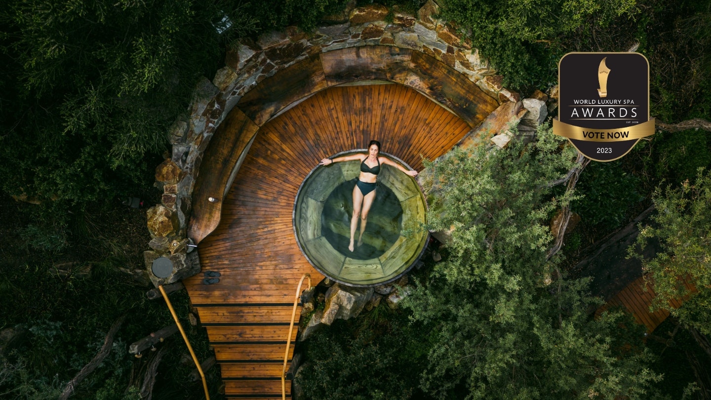 A drone shot of a woman in a barrel pool