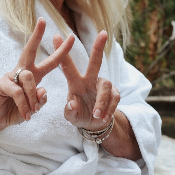 A woman doing two 'Peace' signs with her index fingers