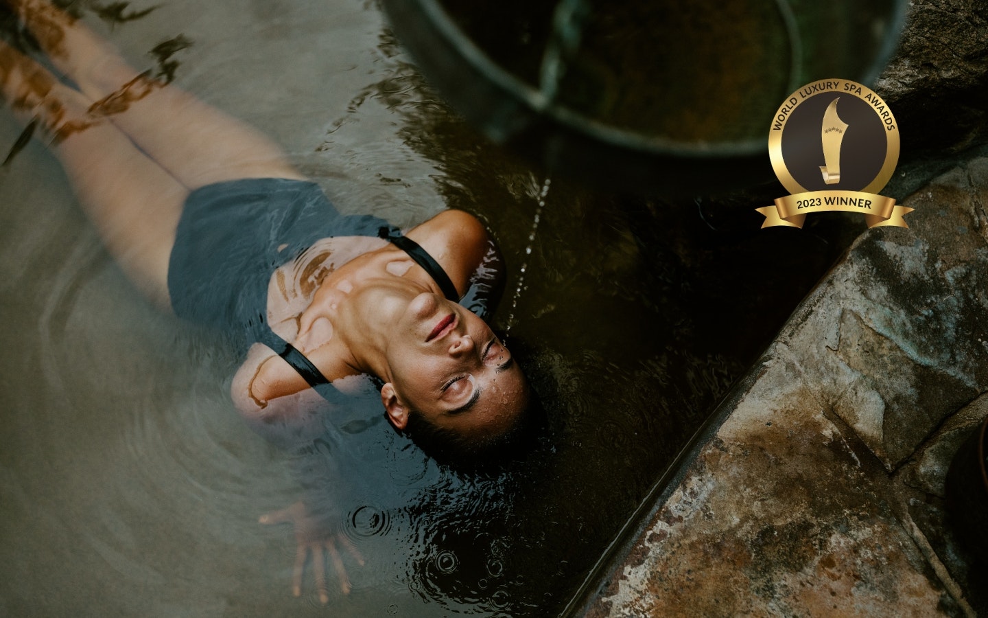 A woman sitting back in a geothermal pool