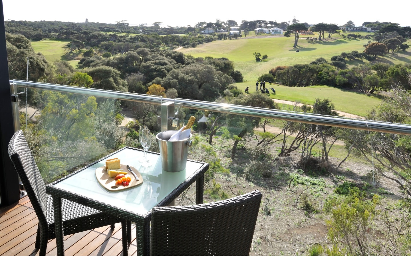 A table on a balcony looking at the view of a golf course