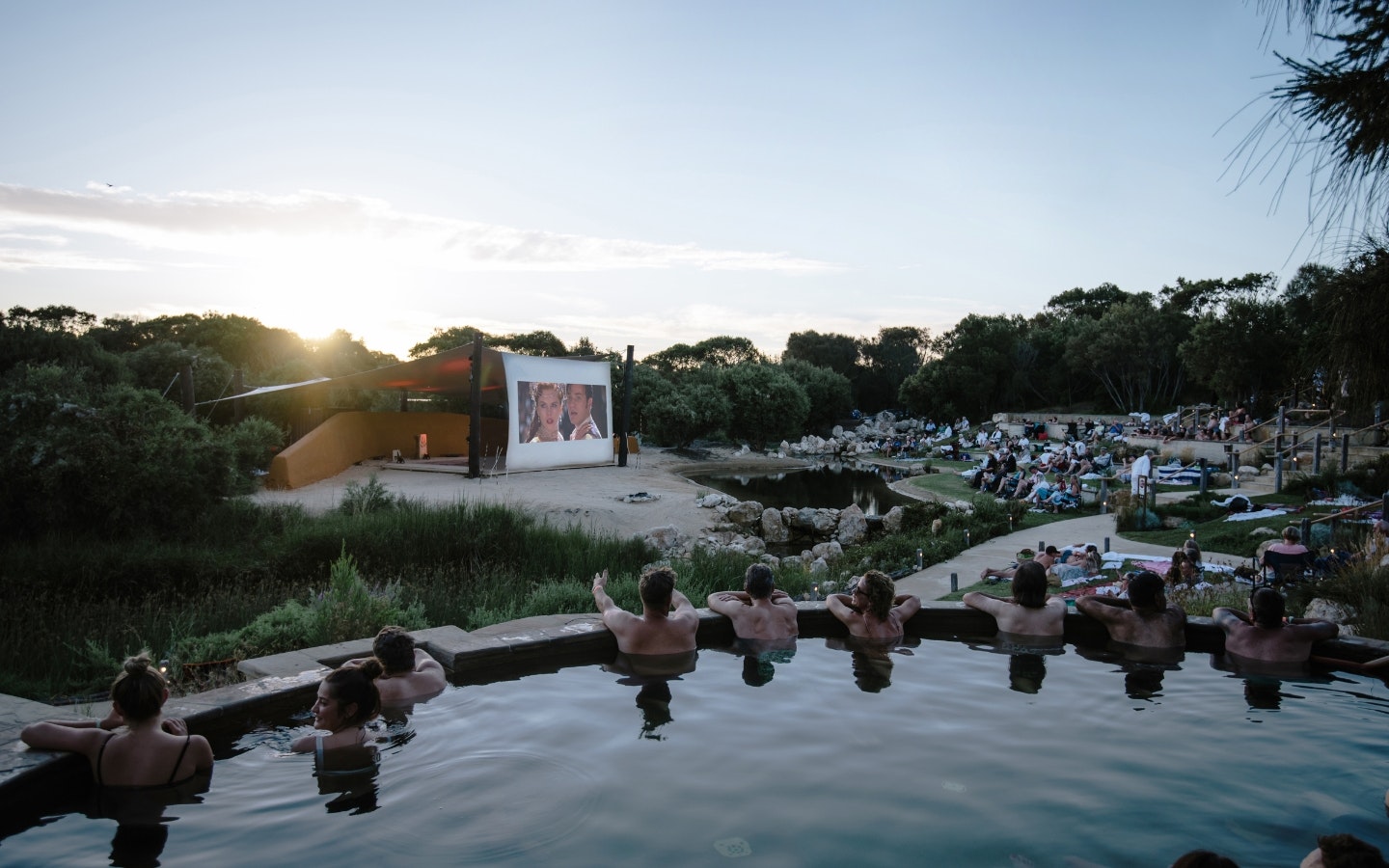 People in a geothermal pool watching cinema