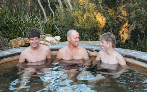 A father & two sons bathing at Peninsula Hot Springs