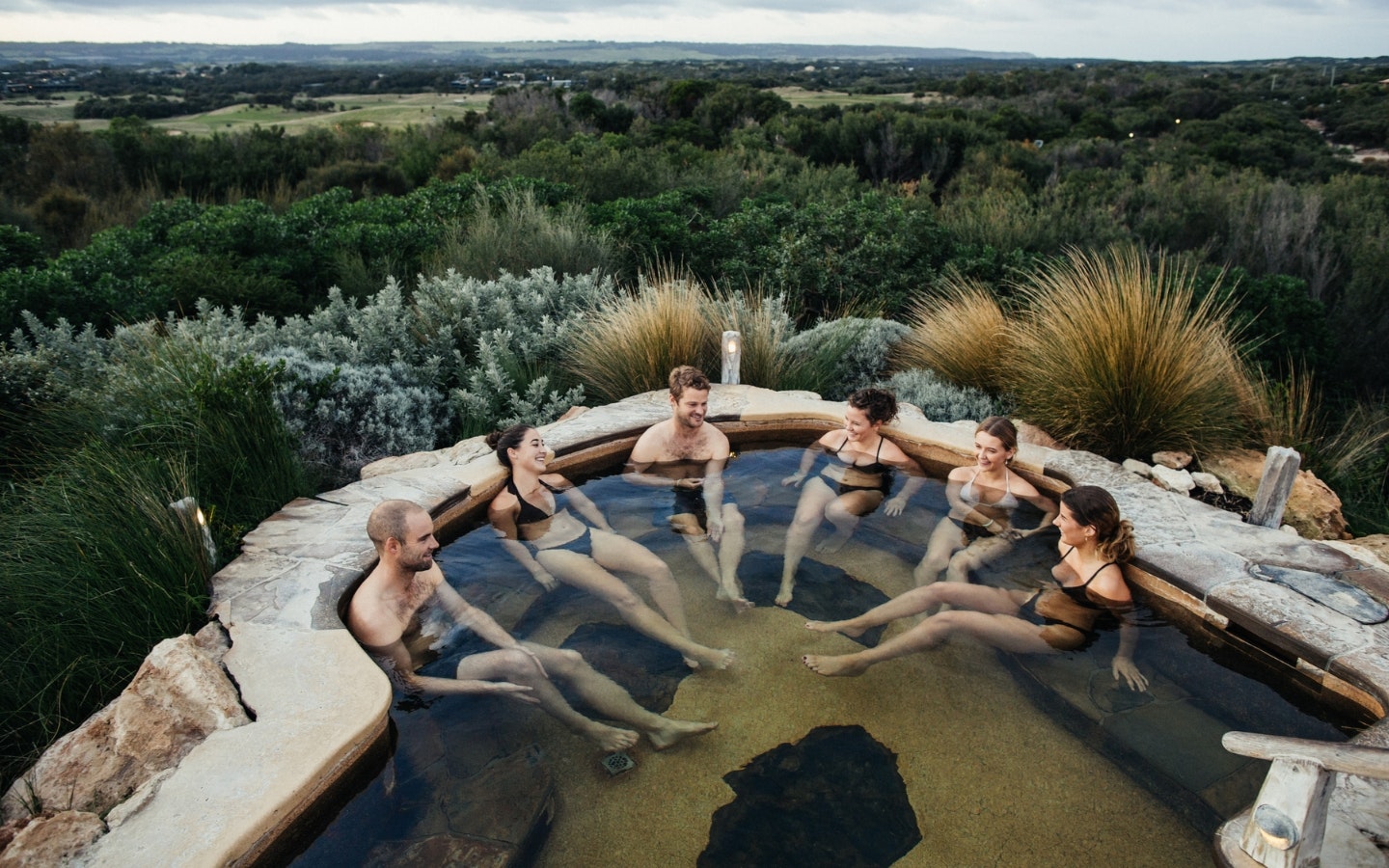 A group of friends bathing in the Hilltop hot spring pool