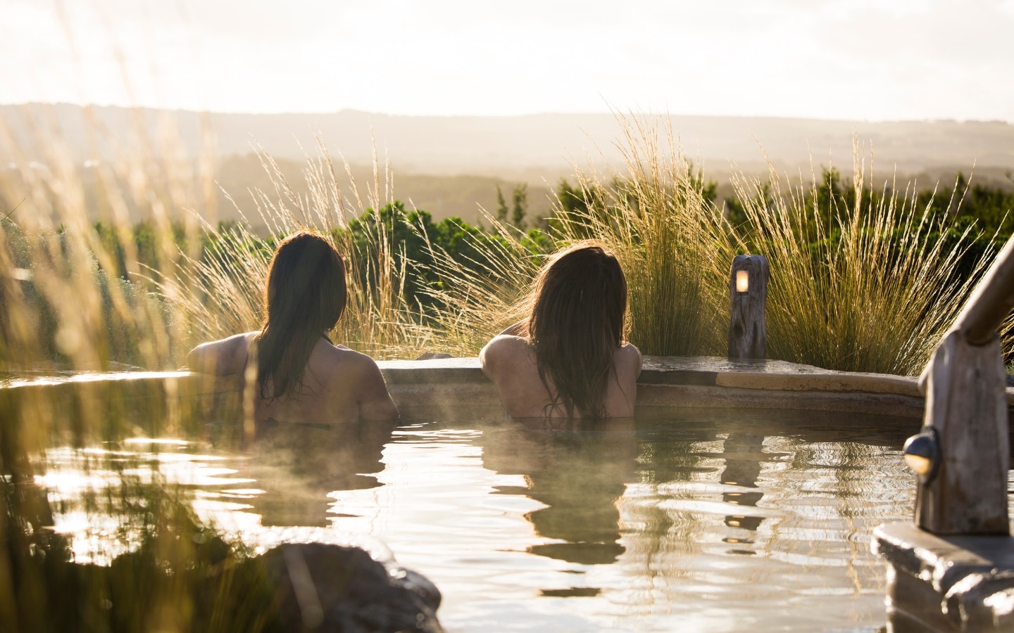 Two young women bathing at hilltop in winter
