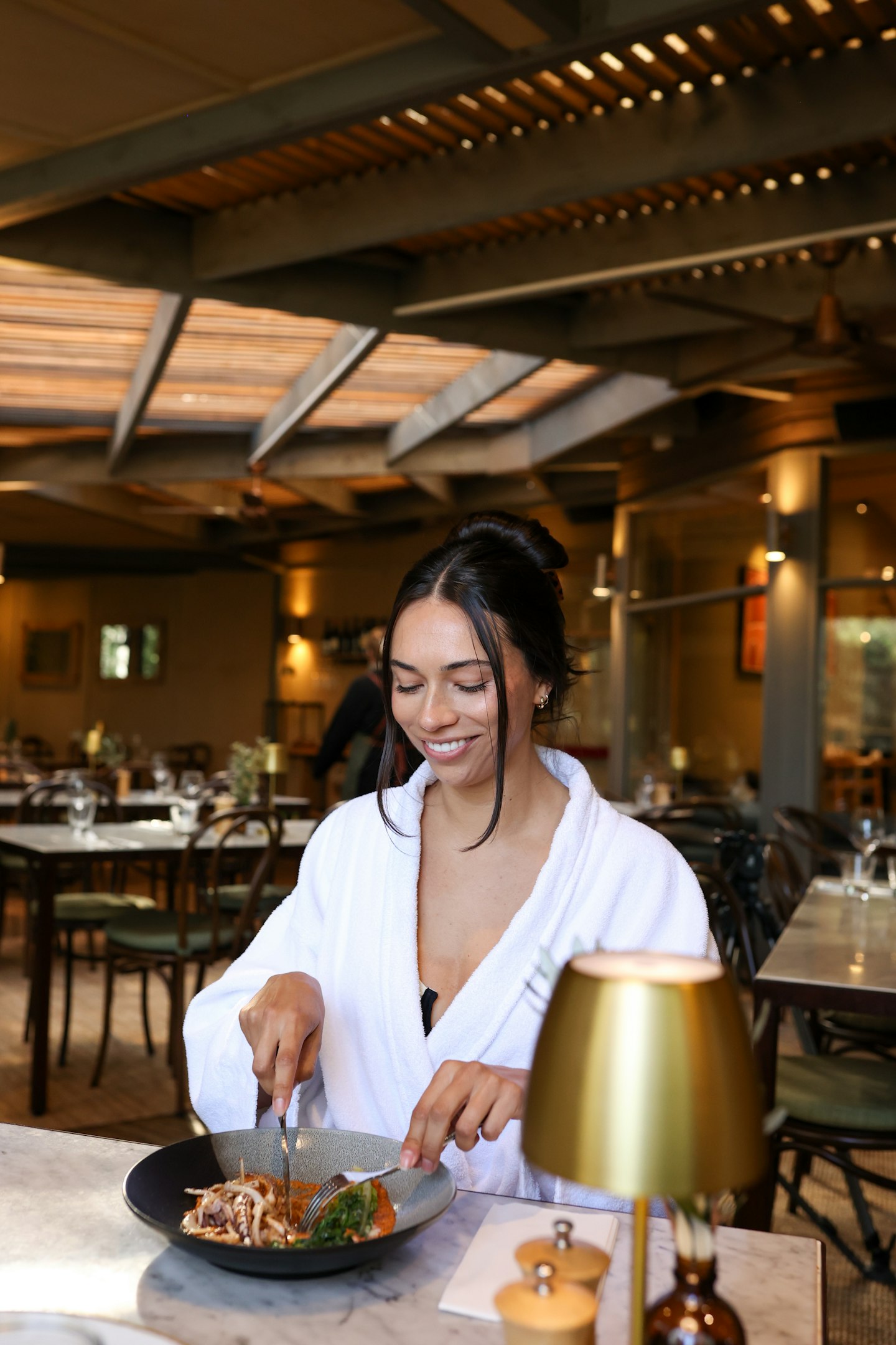 A woman dining in a white robe