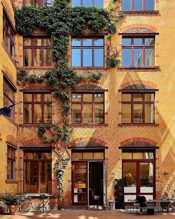 Exterior of Sofi bakery in Mitte showing brick and walled plants