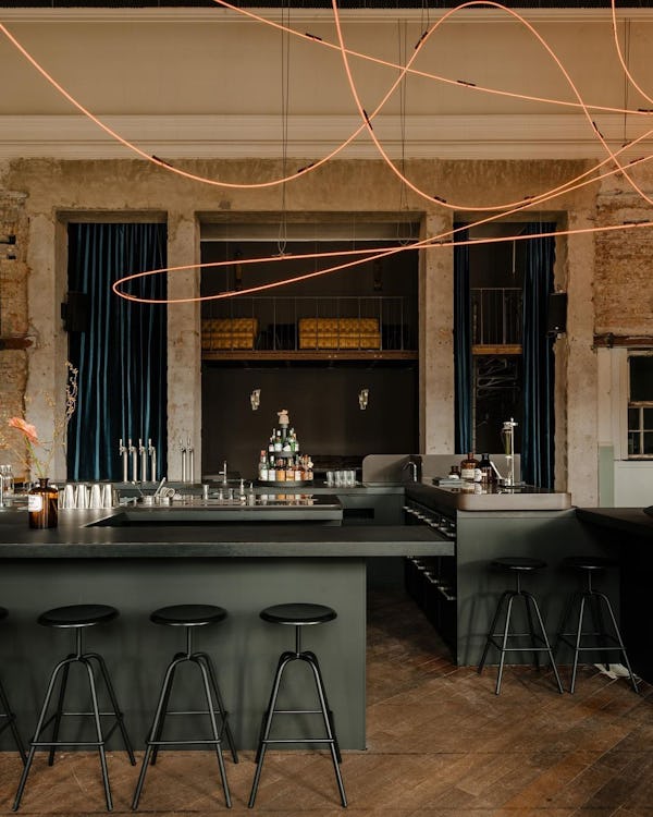 Kink bar interior with overhanging neon light structure