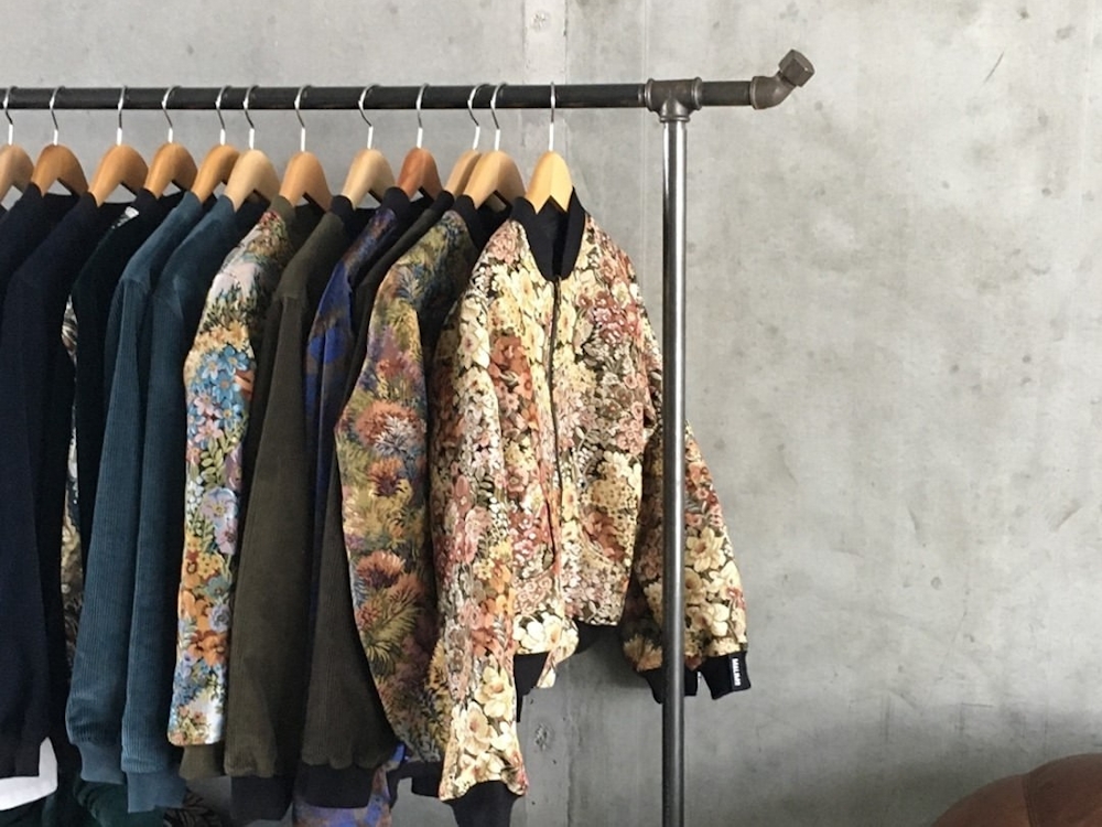 Rack of Yahmo jackets hanging in front of a concrete wall