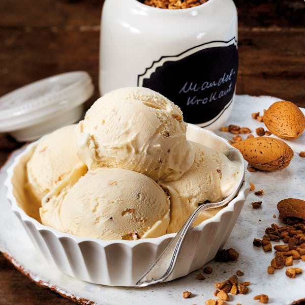 ice cream in a bowl next to a jar of nuts