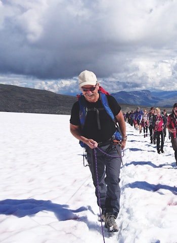 FAMILIETUR TIL GALDHØPIGGEN:: En søndag med solskinn midt i juli er det mange som vil til topps på Galdhøpiggen (2469 moh.). Rekke på rekke krysser Styggebrean innbundet i tau. Foto: Erlend Sande tur til Galdhøpiggen familie
