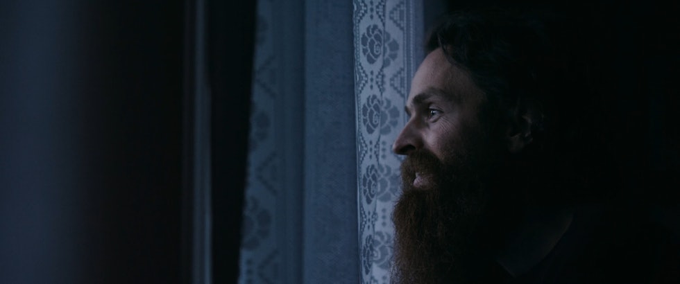 Dagdrømmer. Foto: Fenomen Film Magnus Eliassen dagdrømmer ut stuevinduet i Lofoten