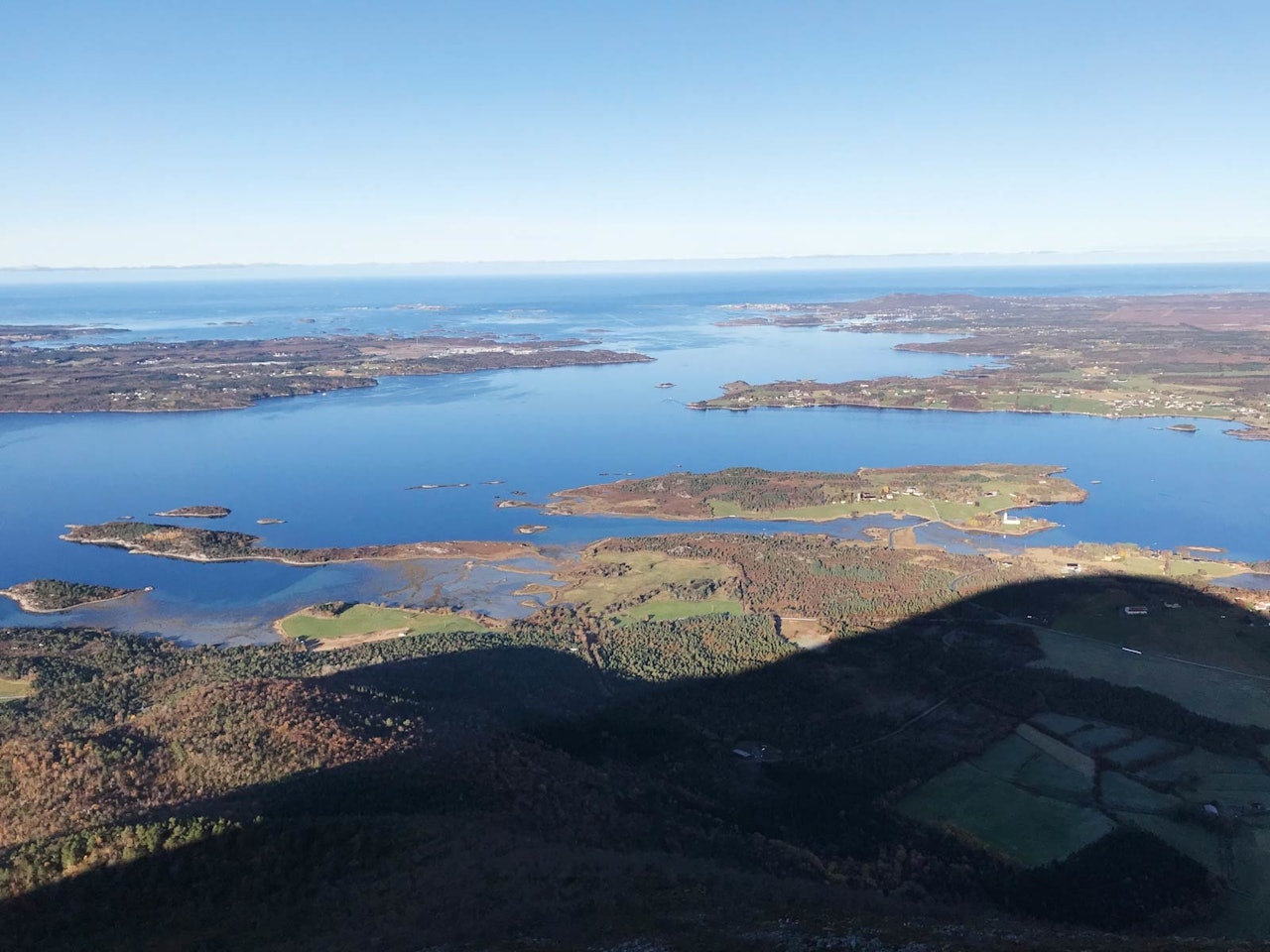 JENDEMSFJELLET: Bildet viser skyggen av østryggen og utsikt fra toppen mot romsdalskysten med Vågsøya, Gossen, Bud og Hustadvika. Foto: Iver Gjelstenli JENDEMSFJELLET: Bildet viser skyggen av østryggen og utsikt fra toppen mot romsdalskysten med Vågsøya, Gossen, Bud og Hustadvika. Foto: Iver Gjelstenli