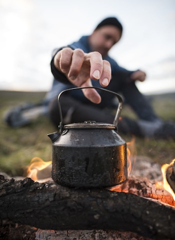 KAFFE PÅ BÅL: Kjelen skal stå tett på flammene for å utnytte effekten. FOTO: Randulf Valle Kaffe på bål i fjellet