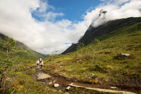 TUREN MED ALT: Stien opp til Storvatnet og videre til topps på Innerdalstårnet inneholder det meste, inkludert fantastisk utsikt mot Innerdalstårnet. Her er turgjengen plassert etter alder, med yngstemann Erlend i front, storesøster Maria i midten, mamma Malin bak og pappa bak kamera. Foto: Tore Meirik Innerdalstårnet