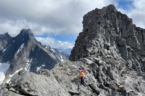 SPENNENDE RYGGTRAVERS I MEKTIGE OMGIVELSER: Siv-Elin Skogen på vei over Dyrhaugsryggen i Hurrungane, med Store Skagastølstind i bakgrunnen. Foto: Tore Meirik Dyrhaugsryggen Jotunheimen Hurrungane