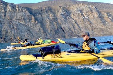 PÅ VEI MOT DELTANESET: I midnattssol. I nærmeste kajakk ser vi: Viljar , kajakk i midten Jan og Leif, kajakk lengst bort Kjersti og Kenneth. Foto: Jim Pedersen svalbard padling isbjørn