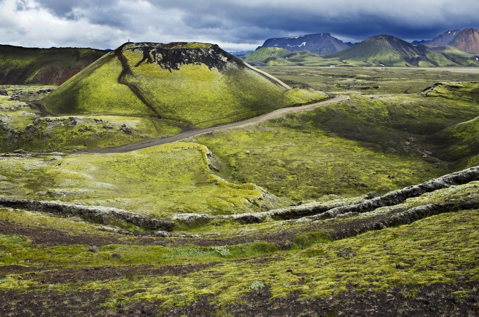 Vulkansk krater med et lite menneske på toppen. Man føler seg fort liten i islandsk natur!