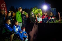 Spente supportere og lagledere studerer skjermen som viser kartet med løypene og GPS-trackingen. Spente supportere og lagledere studerer skjermen som viser kartet med løypene og GPS-trackingen.