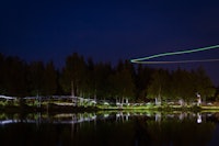 Hodelyktene danner kunstneriske striper langs vannkanten. Fra luften filmer en drone løperne. Hodelyktene danner kunstneriske striper langs vannkanten. Fra luften filmer en drone løperne.