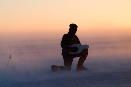 VINDFULLT: Bjørn har funnet frem isgitaren, akkompagnert av den fryktede Piteraq-stormen på Grønland. Dette er en vind forårsaket av to møtende lavtrykk, og kan resultere i vindstyrke opp mot 50-80 meter i sekundet. Foto: Tor Berge 