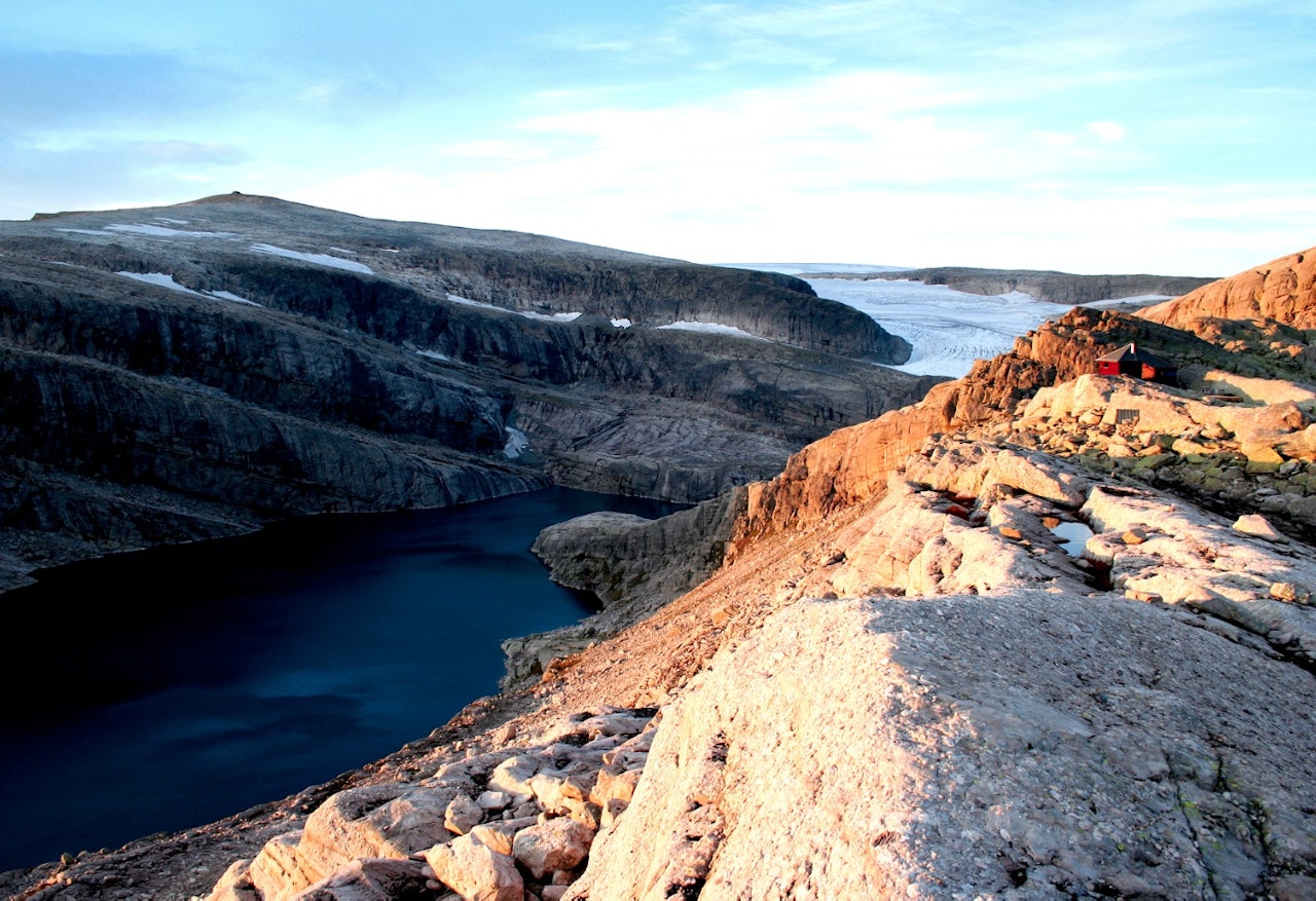 GJEGNABU I KVELDSSOL: På bandet mellom Gjegnalundsbreen og Ålfotbreen ligger den røde, lille hytta Gjegnabu i med fjellet Gjegnen i bakgrunnen. Foto: Sandra Lappegard GJEGNABU