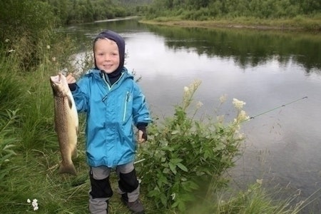 TØFFING: Jon Andreas (5) fikk denne sværingen av en fisk på fisketur i Dividalen. Se video i saken. Foto: Familien Rønneberg