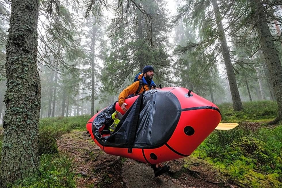 MOBILE: En packraft veier vanligvis fra tre til fire kilo, ekstrautstyr inkludert, og kan lett bæres under armen eller festes på sekken. Når du vandrer i skog er det som oftest førstnevnte som gjelder. Foto: Axel Munthe-Kaas Hærland Bæring av packraft oslomarka nordmarka