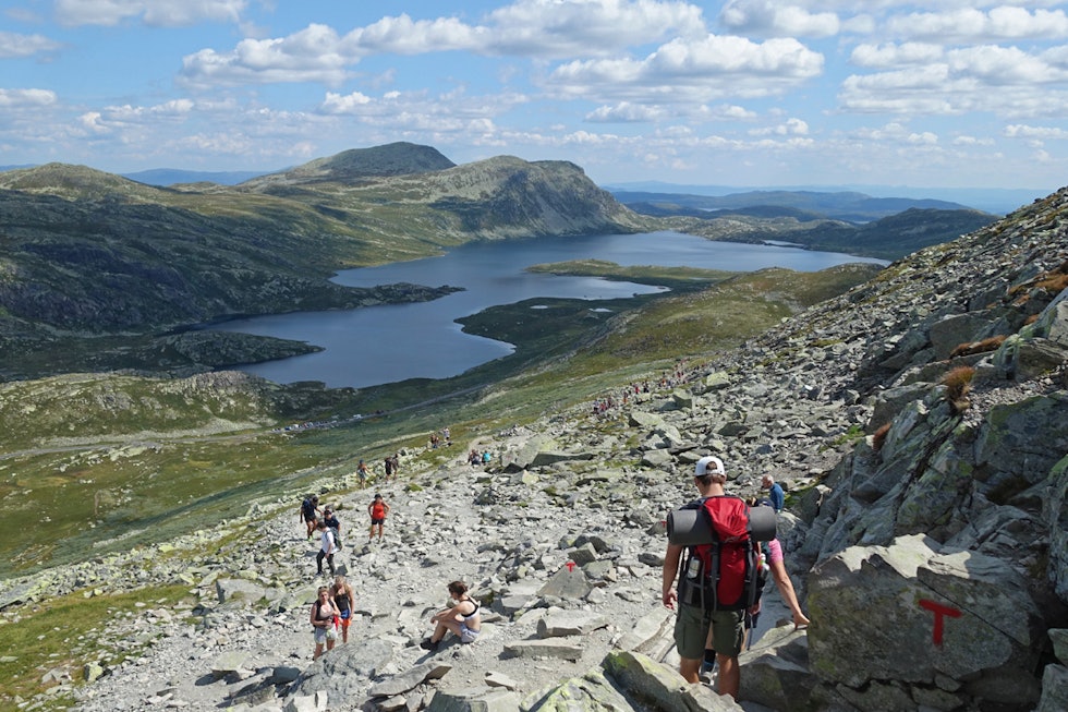 Turen går på steinete underlag, noe som er hardt for bena. I bakgrunnen ser du Heddersfjell med Hulderhola. Foto: Erlend Larsen Gaustatoppen turguide utemagasinet