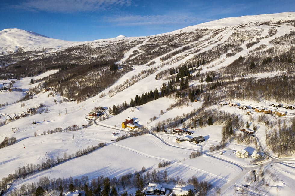 BJORLI: Fra skisenteret mot Einbuløypa over jordet. Til venstre for alpinbakkene svinger nederste del av Fjelløypa seg opp gjennom skogen, og forsvinner over kanten omtrent der det lille fjellet stikker opp i horisonten. Foto: Matti Bernitz Pedersen Bjorli