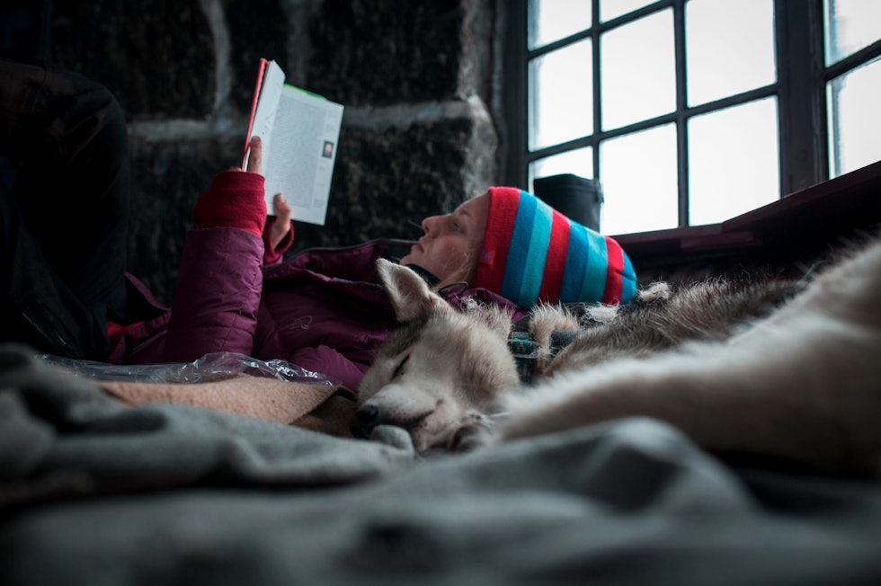 ROLIG START: Da jeg våknet på morgenen og ikke kunne se på grunn av snøføyka, la jeg en ekstra vedkubbe i ovnen og leste en bok til jeg var klar for å møte vinden og den våte snøen. Foto: Marte Stensland Jørgensen styggemannshytta