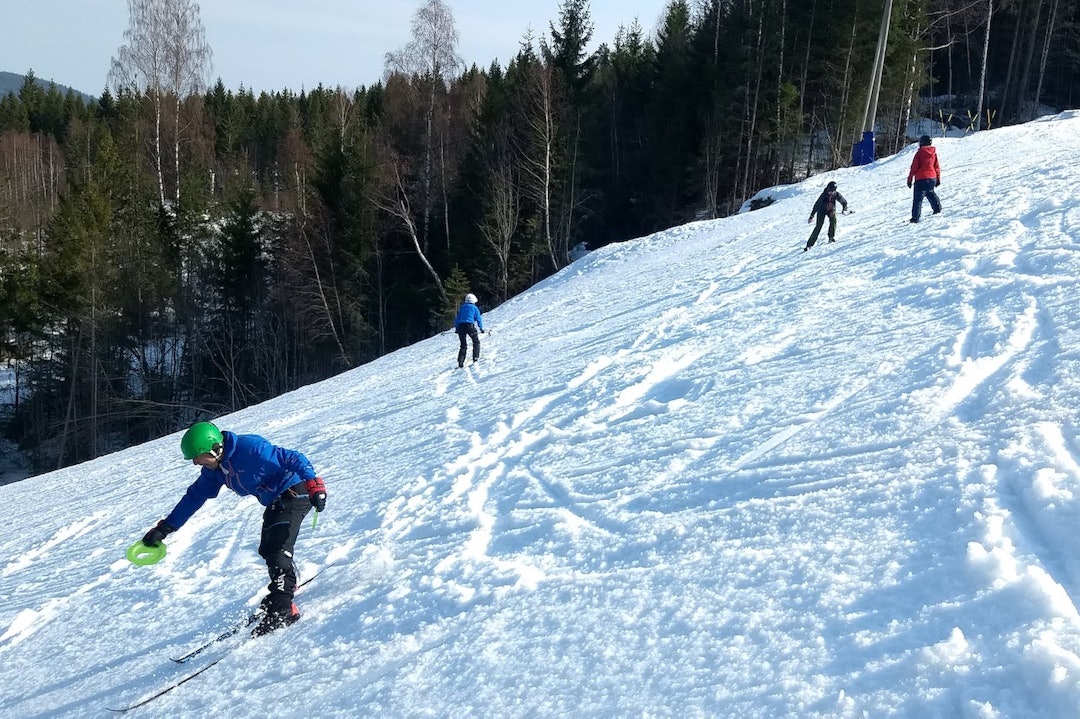 Med grønne tallerkener i hendene og klyper på vottene får elevene til Pål-Trygve Gamme individuelle påminnelser om tyngdeoverføring og andre elementære prinsipper for fjellsckikjøring. Foto: Pål-Trygve Gamme Med grønne tallerkener i hendene og klyper på vottene får elevene til Pål-Trygve Gamme individuelle påminnelser om tyngdeoverføring og andre elementære prinsipper for fjellsckikjøring. Foto: Pål-Trygve Gamme