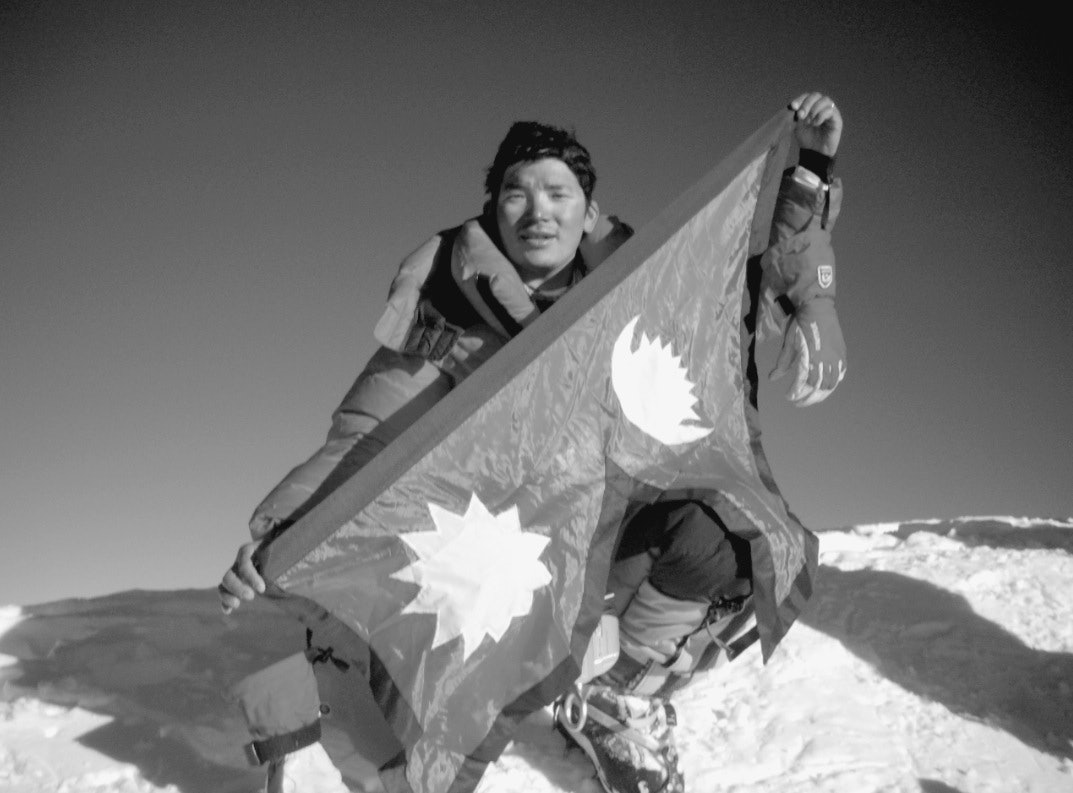 Da Chhiring nådde toppen av K2, brettet han ut det nepalske flagget for å feire. Han nådde toppen klokka 18.37, for sent til å unngå å klatre ned i kveldsmørket og kulden. Foto: Pemba Gyalje Sherpa