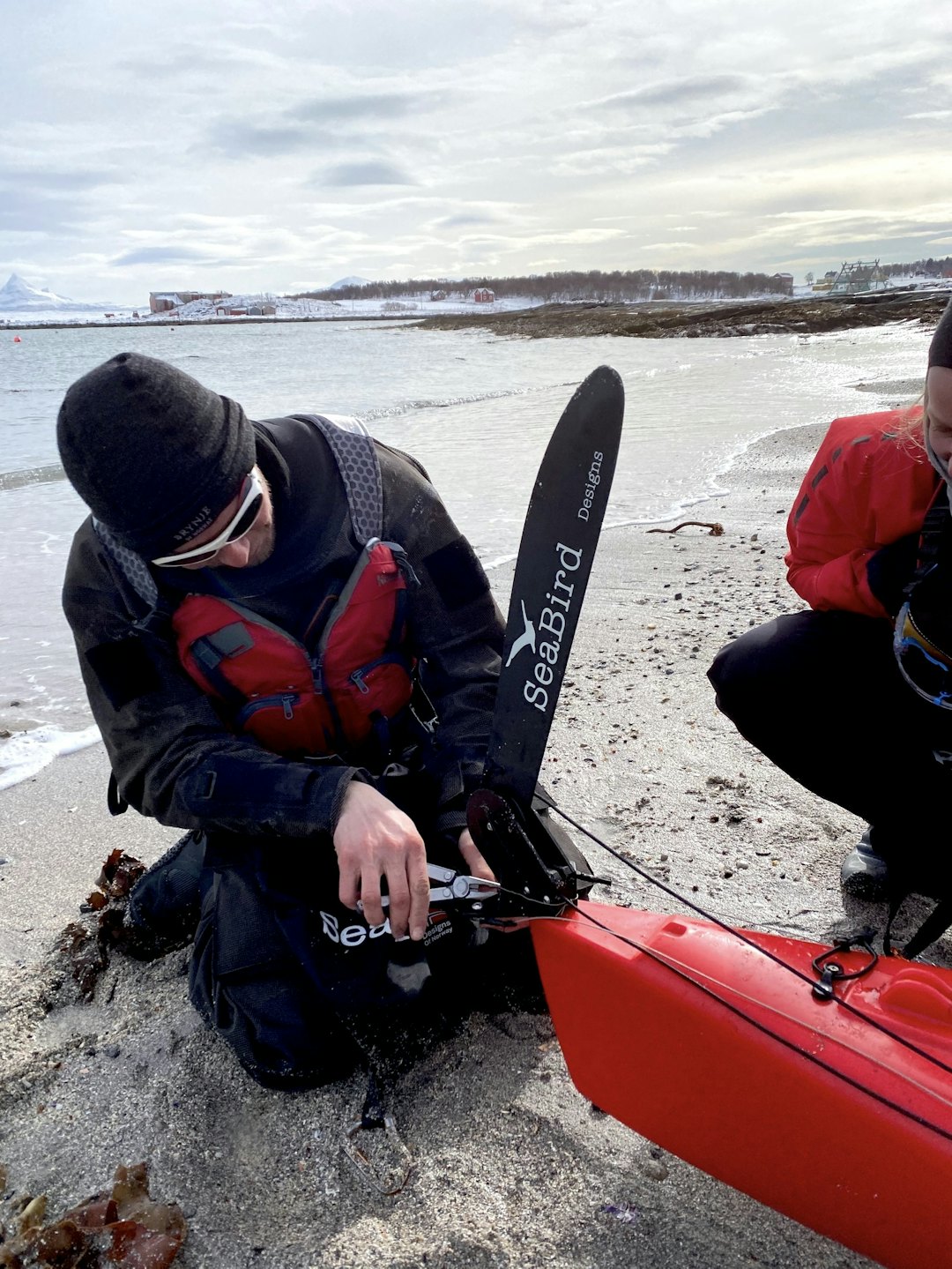 REPARERING: Mekking av ror på Sandsøya. Roret til Mina falt av mellom Senja til Hinnøya. Vi måtte reparere det med noe streng og svivler fra fiskekroker. Heldigvis er Øystein flymekaniker og turens Mac-Gyver. Foto: Tor Wigum fikse ødelagt turutstyr