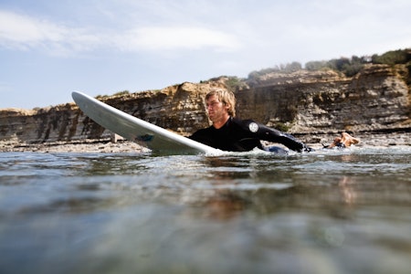 PADLING: Ligger du for langt bak på brettet, vil store deler av brettet bremse, slik at du ikke får nok fart til å komme med bølgen. Dessuten tar det unødvendig mye krefter. Foto: Christian Nerdrum. PADLING: Ligger du for langt bak på brettet, vil store deler av brettet bremse, slik at du ikke får nok fart til å komme med bølgen. Dessuten tar det unødvendig mye krefter. Foto: Christian Nerdrum.