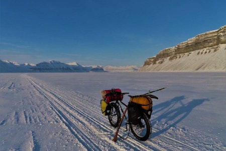 FIN STØTTE: Det er ikke hver tur man bruker våpen som sykkelstøtte. Foto: Santi García bikepacking fatbike svalbard