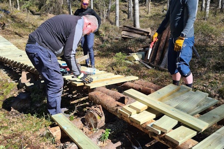ARBEIDSIVER: I løpet av en formiddag hadde dugnadsgjengen skrudd sammen 77 terrassebord og fått på plass den nye kloppen i Pioneren. Foto: Frode Kaafjeld Pusser opp Pioneren