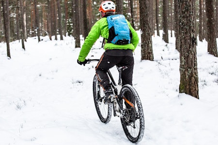 SKOGENS RO: Aslak Mørstad er en ivrig vintersyklist, men passer på å ikke fryse. Med seg i sekken har han for eksempel alltid med seg en god og varm dunjakke. Foto: Christian Nerdrum