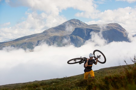 BÆR TIL TOPPS: Pedro Matos tar sykkelen på skuldrene opp mot Dregetuva.  stisykling stranda topptur