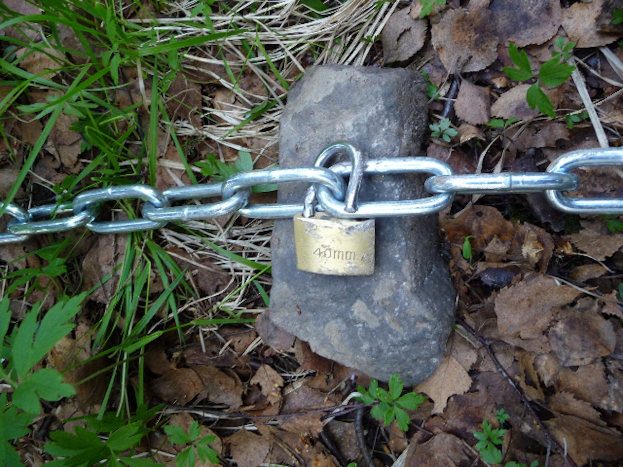 HENGELÅS:  Harald Schønning måtte bruke en stor stein for å få has på hengelåsen og kjettingen. Foto: Harald Schønning HENGELÅS:  Harald Schønning måtte bruke en stor stein for å få has på hengelåsen og kjettingen. Foto: Harald Schønning