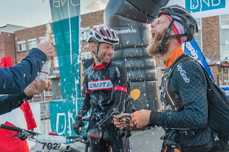 Erik Skovgaard Knudsen og Per Thomsen tok seg et bad i champagne etter å ha syklet 70 mil over Finnmarksvidda. (Foto: Venche Jensen)