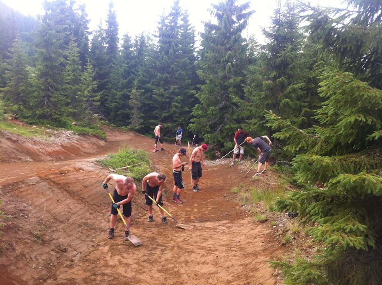 INNSATS: Sykkelturister og lokale ildsjeler stod sammen i arbeidet for å redde og reparere løypene som fikk juling av værgudene. Foto: Hafjell Bike Park hafjell bike park