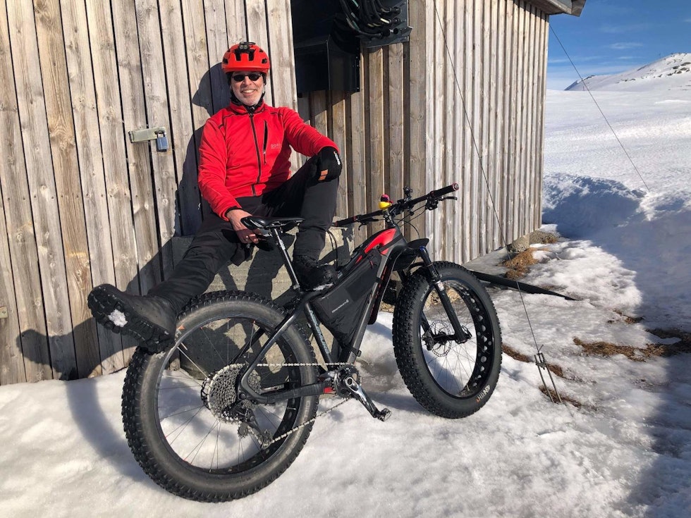 PAUSE: Magnus Lindaas tok seg tid til å nyte vårsola i hytteveggen på Haukelifjell. Foto: Gøran Strand Blavik Fatbike Haukeli