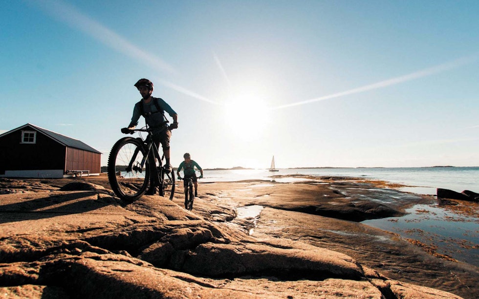 SOMMERFRI: Thomas B. Svendsen og Morgan Bakken sykler med morgensola i ryggen utenfor Kragerø.