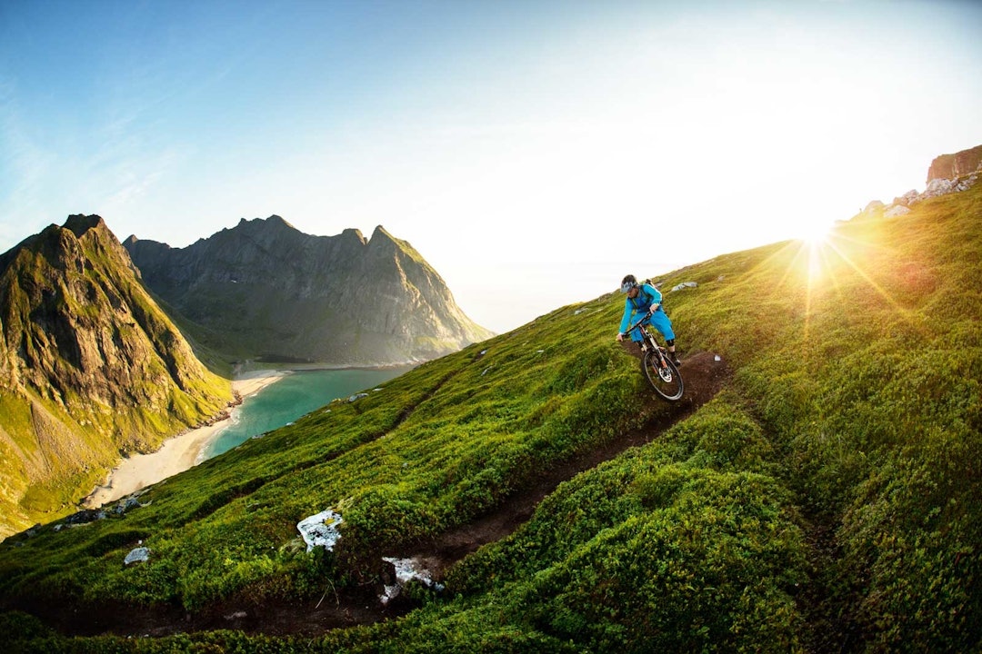 SOMMERDRØM: Tommy Amundsen legger seg over i en sving ned fra Ryten, med Kval-vika langt der nede. Stisykling-lofoten-6