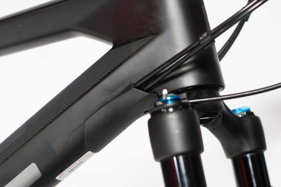 DOBBEL FUNKSJON: Inngangen for vaierne fungerer også som styrestopper slik at du ikke ødelegger ramma ved at gaffelkrona eller styret slår borti i et krasj. DOBBEL FUNKSJON: Inngangen for vaierne fungerer også som styrestopper slik at du ikke ødelegger ramma ved at gaffelkrona eller styret slår borti i et krasj.