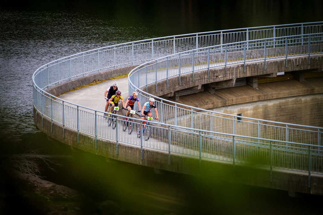DAMPASSERING: På fagspråket har jeg lært at det jeg kaller demning egentlig er en dam. Men uansett. Det er ikke mange ritt som har en dampassering som Østmarkrittet. Her sto jeg på kanten av en bratt skrent, omsvermet av mygg og siktet gjennom en glippe i et grantre. (foto: Snorre Veggan) østmarkrittet-9903a