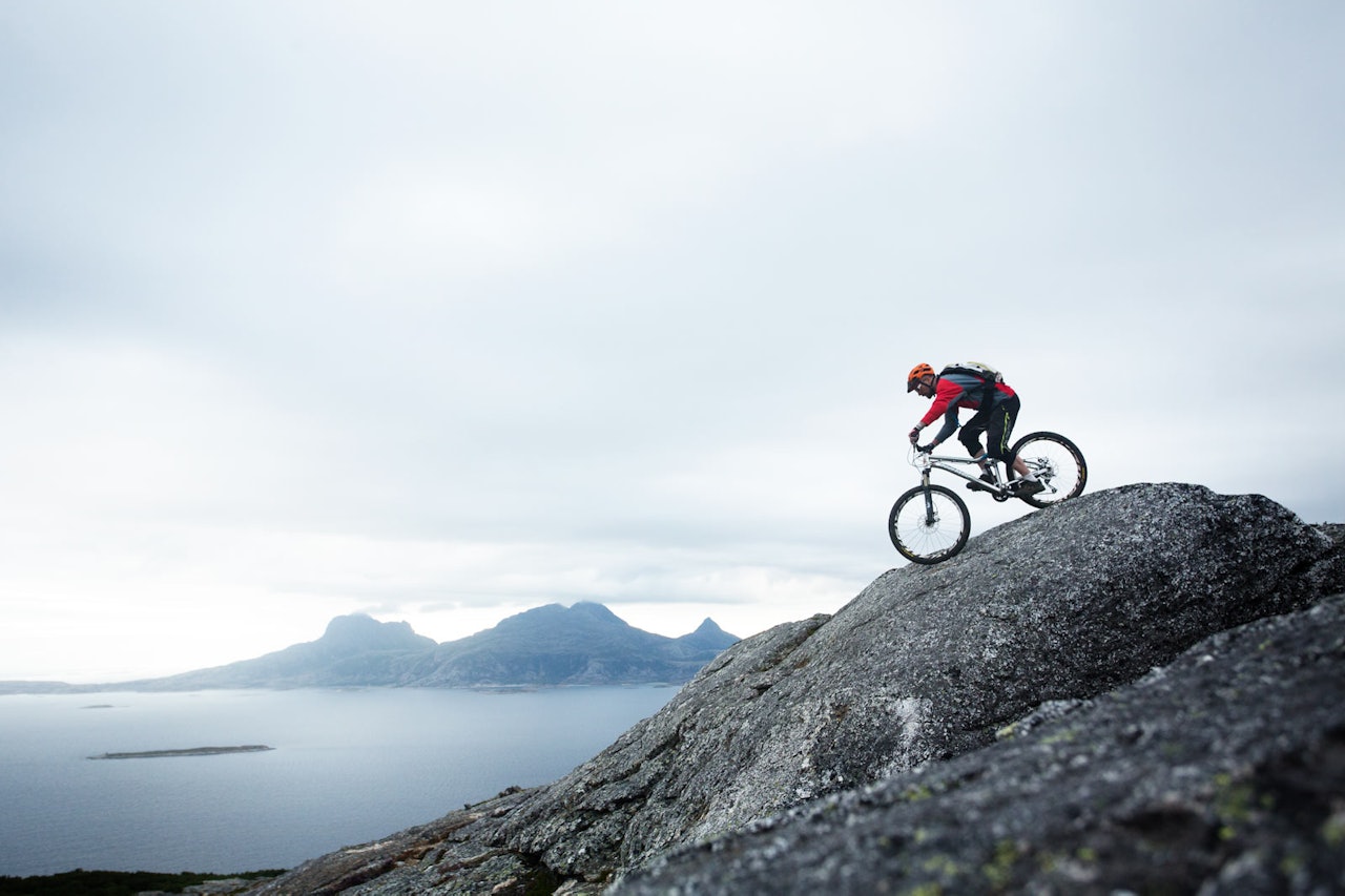 Andreas Klette sykler Framsia ned mot Bodø, med øyen Landegode i bakgrunnen. / Stisykling i Norge. Andreas Klette sykler Framsia ned mot Bodø, med øyen Landegode i bakgrunnen. / Stisykling i Norge.